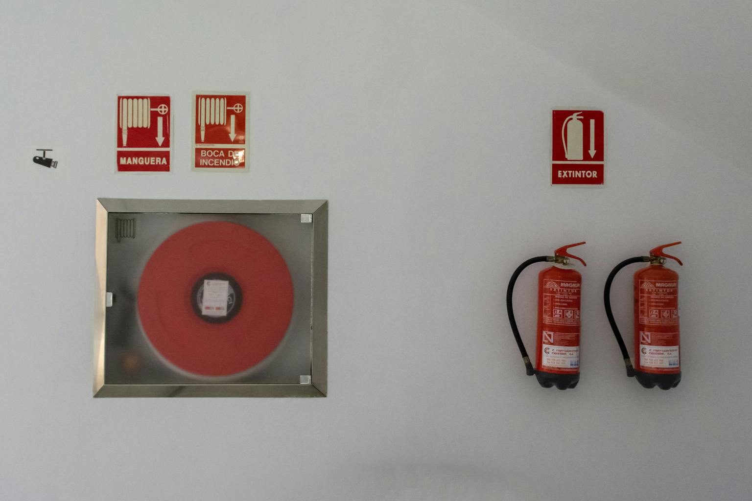 fire-safety-setup-with-extinguishers-and-hose-reel-on-a-white-wall-for-emergency-preparedness.-16517206-1536×1024